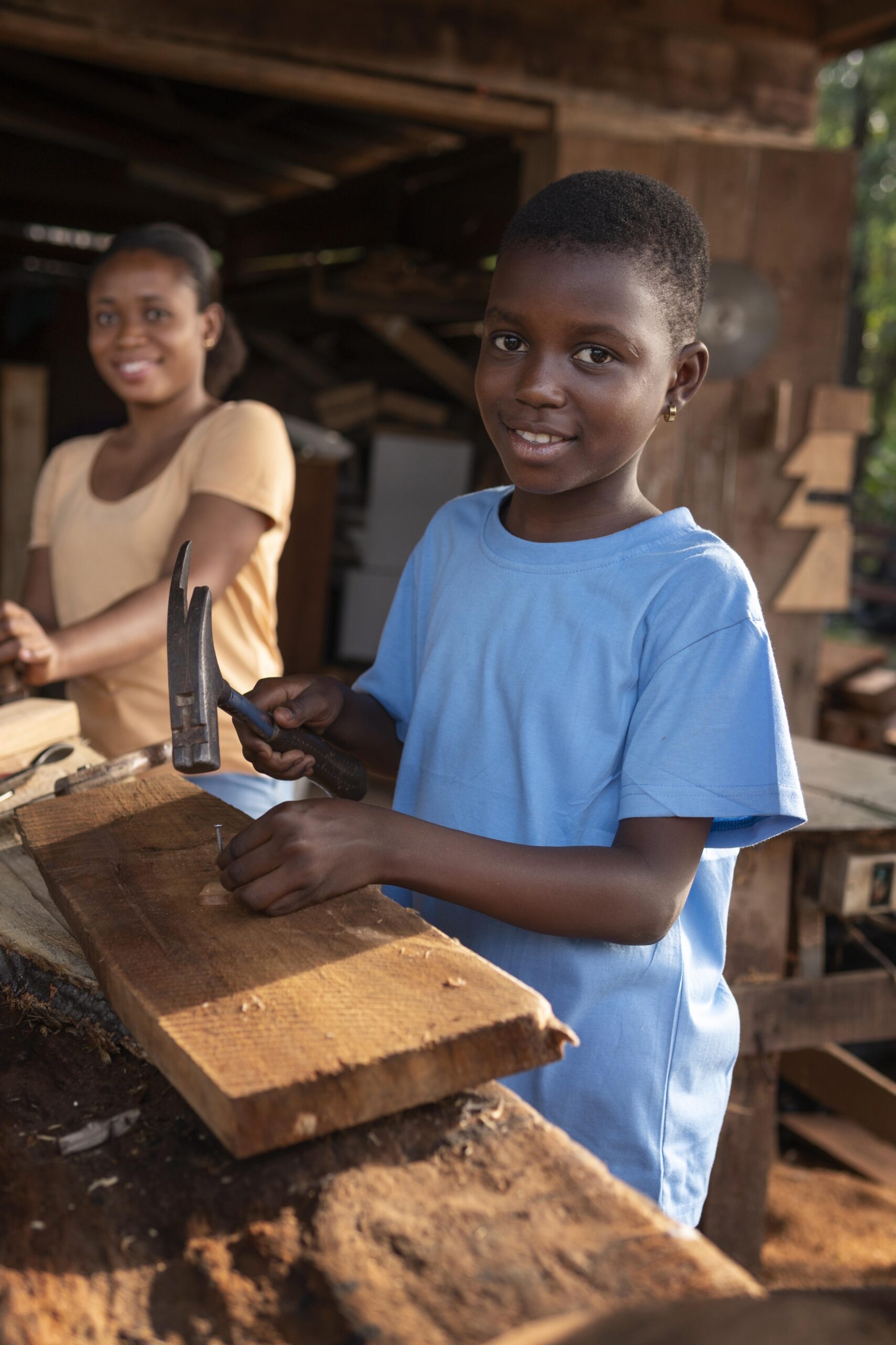 medium shot kid with hammer hitting nail
